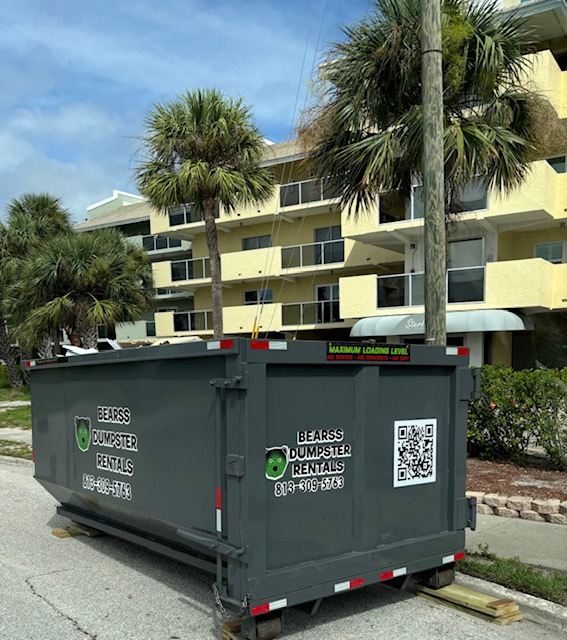 Rented dumpster with construction debris in front of condo