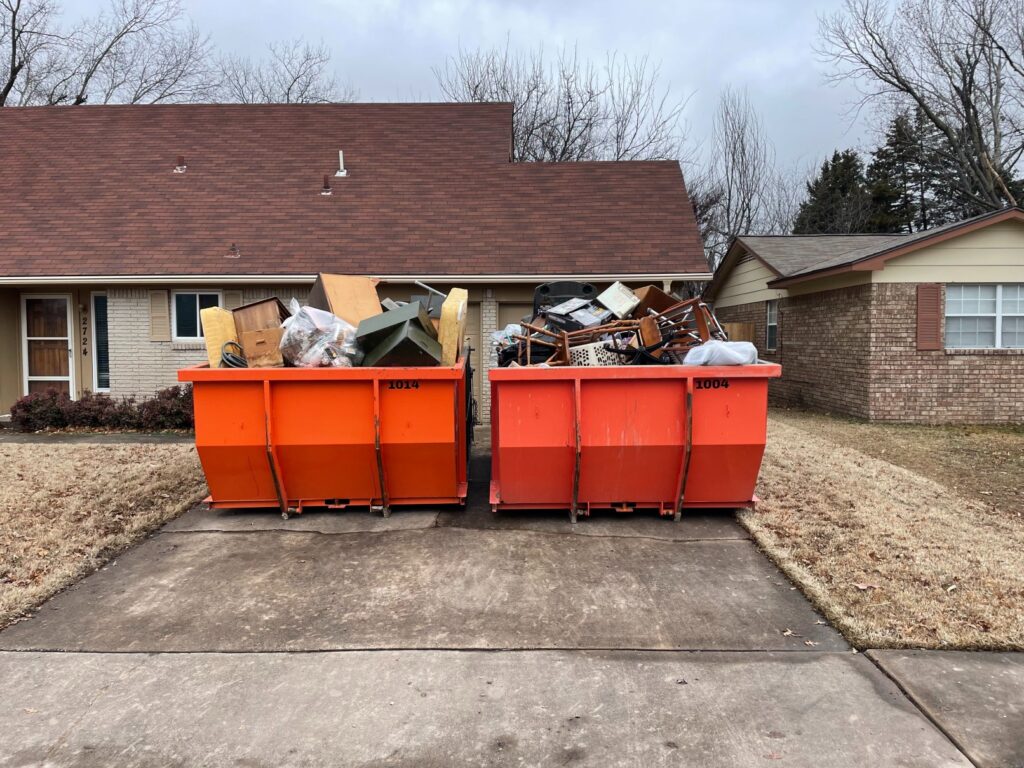 Bison Bins dumpsters filled with trash outside a house.