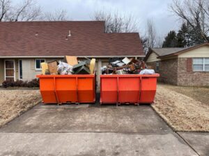 Bison Bins dumpsters filled with trash outside a house.